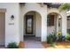 Front entry with arched entryway and decorative door at 24273 Spartina Dr, Venice, FL 34293