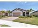 Single-story home with tan garage door and red tile roof at 24273 Spartina Dr, Venice, FL 34293