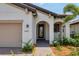 Front entry with arched entryway and decorative door at 24273 Spartina Dr, Venice, FL 34293