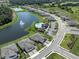 The property is surrounded by mature landscaping and a serene lake with community amenities like a pool at 12586 Oak Hill Way, Parrish, FL 34219