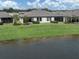 Backyard featuring a well manicured lawn, mature landscaping, screened in porch and lovely pond view at 12586 Oak Hill Way, Parrish, FL 34219