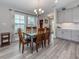 Elegant dining room featuring modern gray floors, a chandelier, and plenty of natural light at 12586 Oak Hill Way, Parrish, FL 34219