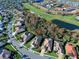 Aerial view of a residential area with lush landscaping and a golf course in the background at 381 Marsh Creek Rd, Venice, FL 34292