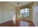 Well-lit bedroom with hardwood floors, closet, ceiling fan, and window views of the lush outdoors at 381 Marsh Creek Rd, Venice, FL 34292