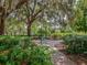 Park bench underneath large oak trees with Spanish moss at 5650 Mashie Cir, North Port, FL 34287