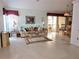 Living room with tile floors, sofa, and access to screened porch at 5650 Mashie Cir, North Port, FL 34287