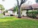 Condo with a large tree and grassy yard at 5650 Mashie Cir, North Port, FL 34287