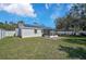 Exterior view of backyard featuring a screened-in patio and lush green lawn at 6738 Brentford Rd, Sarasota, FL 34241