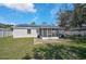 Home's backyard boasts solar panels, a screened-in lanai, and a white fence at 6738 Brentford Rd, Sarasota, FL 34241