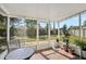 Cozy screened-in patio featuring tile floors, outdoor seating, and views of the backyard, ideal for relaxation at 6738 Brentford Rd, Sarasota, FL 34241
