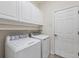 Laundry room with white cabinets and washer and dryer at 23928 Skyflower Ct, Venice, FL 34293