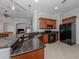 Modern kitchen with dark wood cabinets, granite countertops, and black appliances at 126 Cipriani Way, North Venice, FL 34275