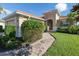 Tan house with tile roof, landscaped yard, and walkway at 126 Cipriani Way, North Venice, FL 34275