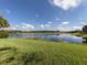 Serene lake view with lush green grass at 126 Cipriani Way, North Venice, FL 34275