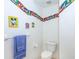 Small bathroom with toilet and Mickey Mouse themed decor at 4195 Fairway Pl, North Port, FL 34287