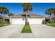 Two-villa exterior with three-car garages and landscaping at 4195 Fairway Pl, North Port, FL 34287