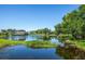 Serene pond with lush greenery and homes in background at 4195 Fairway Pl, North Port, FL 34287