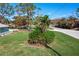 Landscaped front yard with tropical plants and trees at 2480 Alamander Ave, Englewood, FL 34223