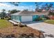 Teal home with a white garage door and paver driveway at 2480 Alamander Ave, Englewood, FL 34223