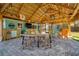 Outdoor patio with tiki bar and dining table under a palapa at 2480 Alamander Ave, Englewood, FL 34223