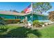 Charming teal house with a well-manicured lawn and American flag at 2480 Alamander Ave, Englewood, FL 34223