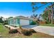 Teal house with a white garage and paver driveway at 2480 Alamander Ave, Englewood, FL 34223