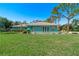 Landscaped lawn and teal house with an inviting entrance at 2480 Alamander Ave, Englewood, FL 34223