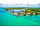 Aerial view of waterfront homes, boat slips and a large building at 4024 Casey Key Rd, Nokomis, FL 34275