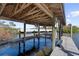 Private boat lift with wooden dock and covered area at 4024 Casey Key Rd, Nokomis, FL 34275
