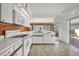 White kitchen features orange backsplash and sliding door to patio at 731 Carnoustie Ter, Venice, FL 34293