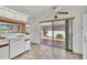 Kitchen with white appliances, orange accent wall, and patio access at 731 Carnoustie Ter, Venice, FL 34293