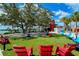 Relaxing community park with red Adirondack chairs and green space at 12458 Somatic Ct, Venice, FL 34293