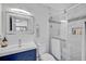 Modern bathroom with a walk-in shower and blue vanity at 6738 Brentford Rd, Sarasota, FL 34241