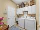 Laundry room with washer, dryer, and ample cabinet space at 2112 S Chamberlain Blvd, North Port, FL 34286