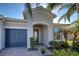 Home's entryway with a covered porch and lush landscaping at 19556 Petrino St, Venice, FL 34293