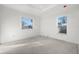 Bright bedroom featuring two large windows and concrete flooring at 1247 Graham Rd, Venice, FL 34293