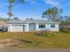 Newly constructed light blue home with a white garage door and landscaping at 1247 Graham Rd, Venice, FL 34293