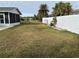 Large backyard with a white fence and green lawn at 1301 Washington Dr, Englewood, FL 34224