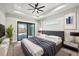 Main bedroom with ceiling fan, sliding doors to patio, and ensuite bathroom at 15004 Alsask Cir, Port Charlotte, FL 33981