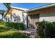 Backyard with a well-maintained lawn, mature hedges, and a sliding door entrance at 172 Southampton Pl # 346, Venice, FL 34293