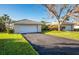 Attached one-car garage with a driveway and well-maintained lawn and mature trees on a sunny day at 172 Southampton Pl # 346, Venice, FL 34293