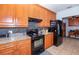 Efficient kitchen with wooden cabinets, tile flooring, granite countertops, and a black refrigerator at 172 Southampton Pl # 346, Venice, FL 34293