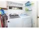 Functional laundry room with modern washer and dryer, storage shelves, and a window at 172 Southampton Pl # 346, Venice, FL 34293