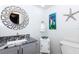 Stylish powder room featuring granite countertop, decorative mirror, and unique wall decor at 172 Southampton Pl # 346, Venice, FL 34293