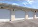 Three-car garage with individual overhead doors and numbered spaces at 200 Gardens Edge Dr # 212, Venice, FL 34285