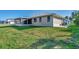 House exterior and grassy backyard with screened patio at 4646 Fallon Cir, Port Charlotte, FL 33948