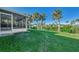 Expansive backyard with lush green grass and a screened-in patio for outdoor enjoyment at 4646 Fallon Cir, Port Charlotte, FL 33948