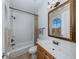 Clean bathroom with tub, shower, vanity, and decorative mirror at 737 Shakett Creek Dr, Nokomis, FL 34275
