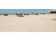 Beach with people relaxing under umbrellas at 737 Shakett Creek Dr, Nokomis, FL 34275