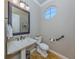 Powder room with pedestal sink, decorative mirror and tiled floor at 737 Shakett Creek Dr, Nokomis, FL 34275